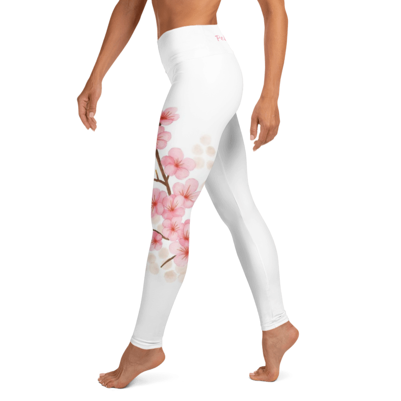 White high-waisted leggings with a pink cherry blossom branch print on the left leg, shown on a model against a white background.
