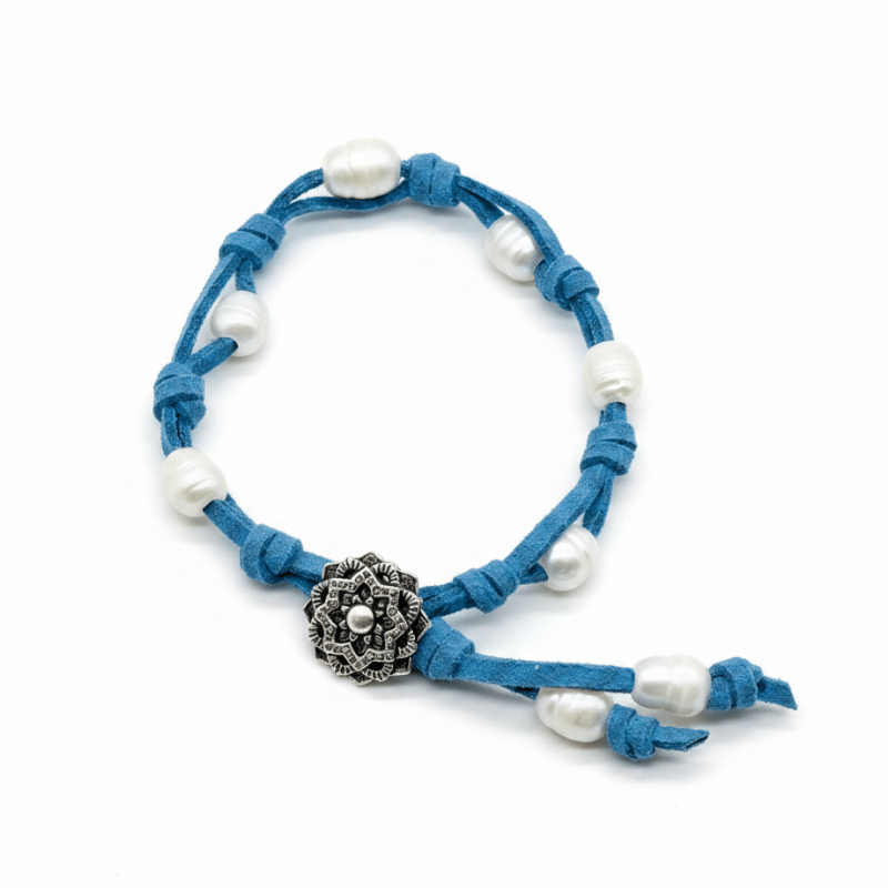 A blue faux-suede cord bracelet with white natural pearls and an antique silver-plated Mandala button, displayed on a clean white background.