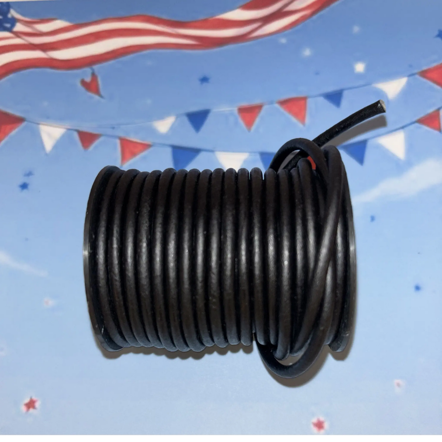 Coiled black leather cord on a blue background with American flags and bunting.