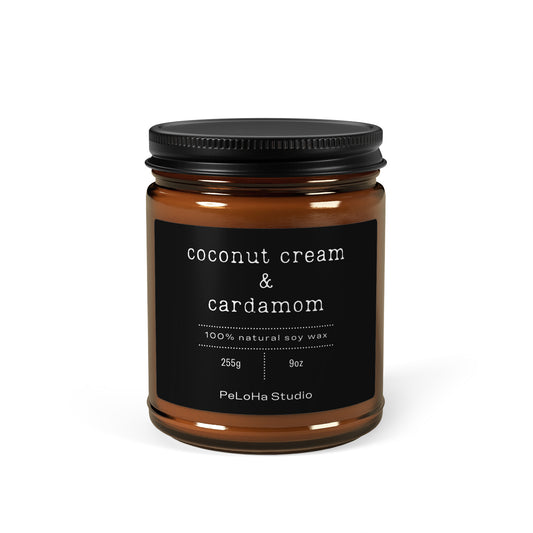 An amber glass jar candle with a black lid and a black label reading 'coconut cream & cardamom' and 'PeLoHa Studio' on a white background.