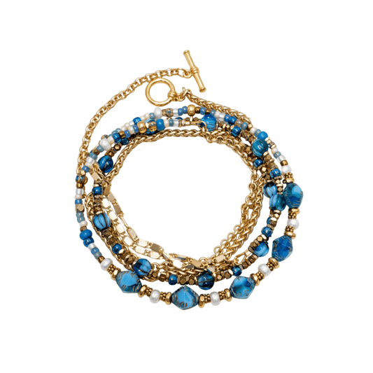 A multi-strand beaded and chain bracelet with blue faceted beads, gold-plated chain links, and a toggle clasp, shown on a plain white background.