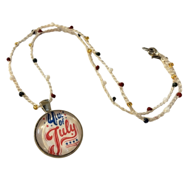 A beaded crochet necklace with a round pendant featuring a patriotic '4th of July' design in red, white, and blue, shown on a plain white background.