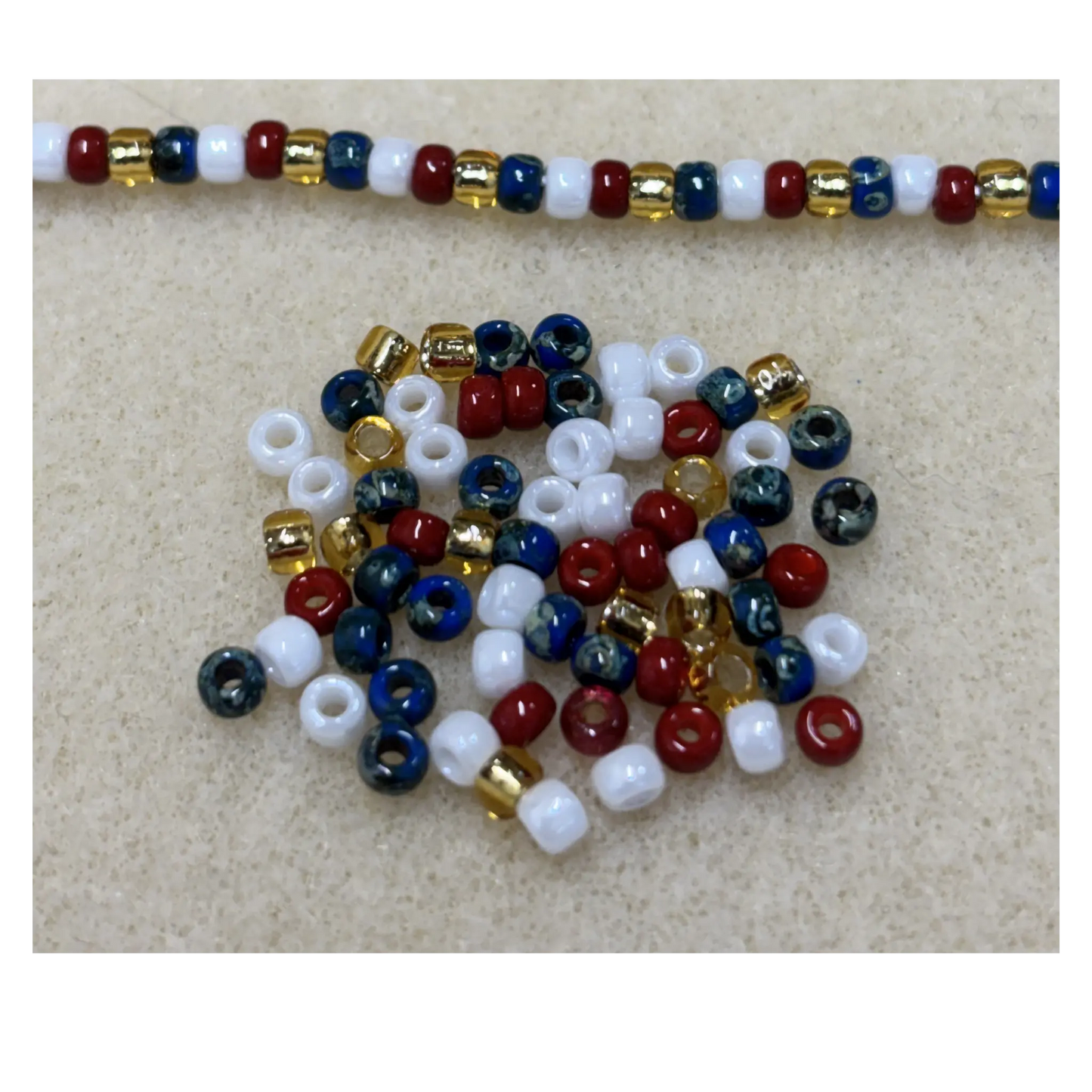Red white and blue beads on a beige surface.