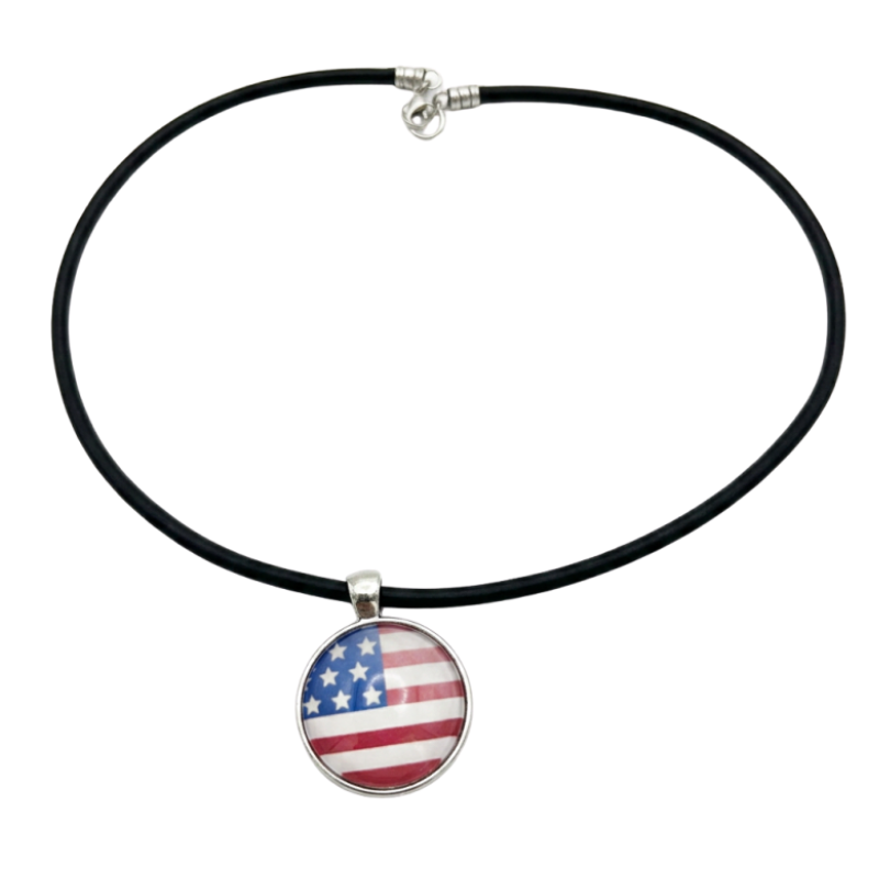 A black leather cord necklace with a round pendant featuring the American flag design, displayed on a clean white background.