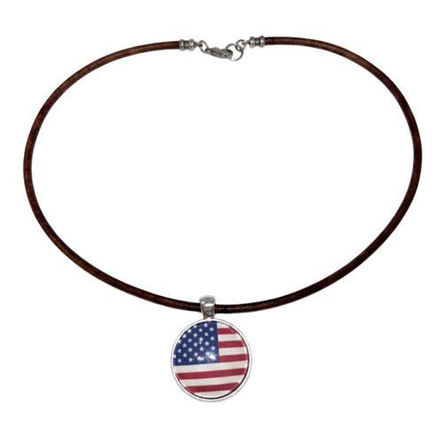 A brown leather necklace with a circular pendant featuring the American flag design, displayed on a solid white background.