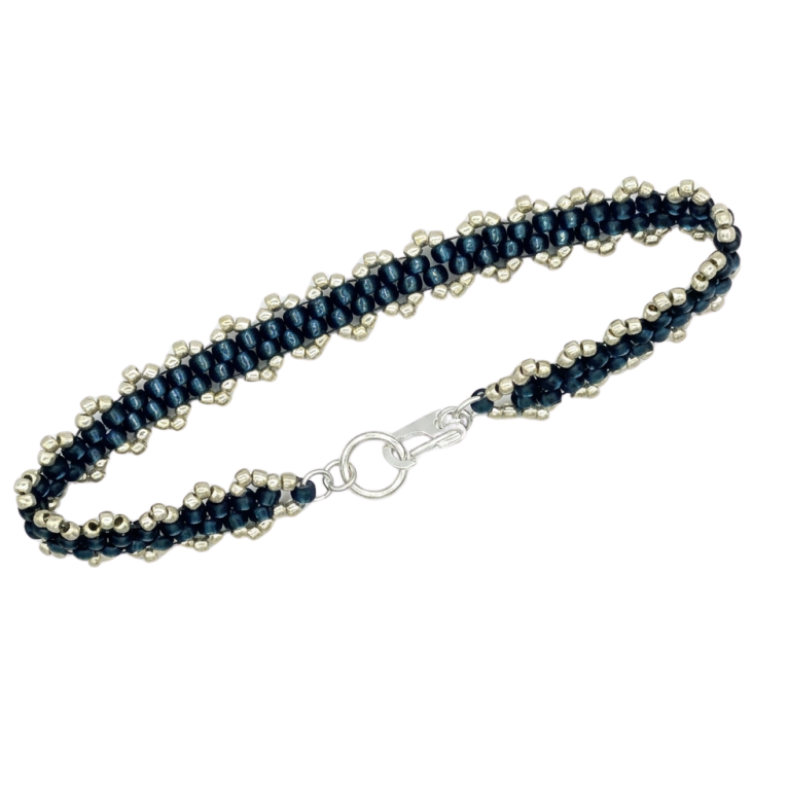 A beaded bracelet featuring dark navy blue seed beads woven with rows of small, metallic silver beads, finished with a silver lobster clasp.