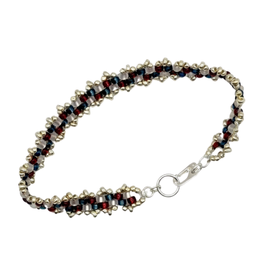 A beaded bracelet featuring alternating rows of red, white, and blue beads, finished with a silver-plated lobster clasp and O-ring closure.