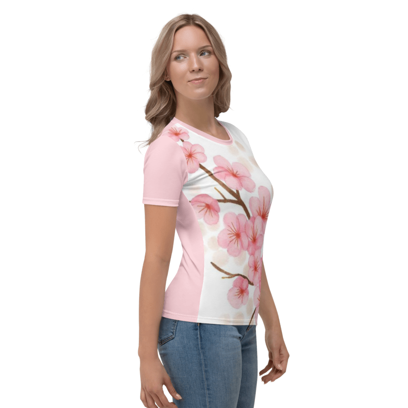 A smiling woman turned to her left,  wearing the Sakura Soul regular-fit t-shirt featuring a watercolor cherry blossom branch graphic on a white background with pink sleeves.