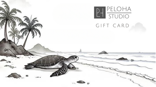 A Peloha Studio gift card featuring a black and white watercolor illustration of a sea turtle on a beach with palm trees and ocean waves.