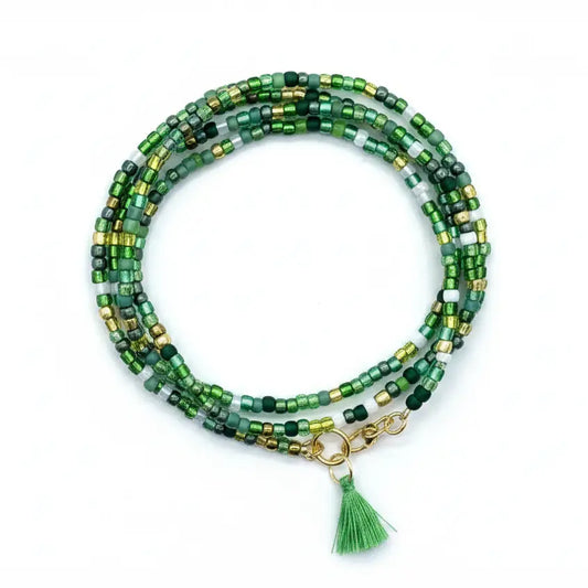 Multi-wrap bracelet with glass beads in shades of green, with a gold-plated clasp on a white background.