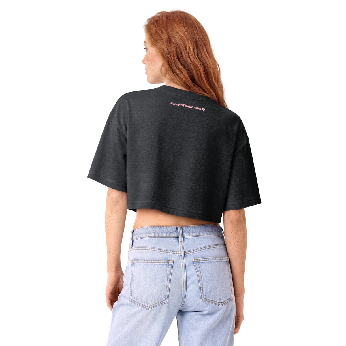 A woman with red hair is shown from the back wearing a dark charcoal gray cropped t-shirt and light blue jeans against a solid white background.
